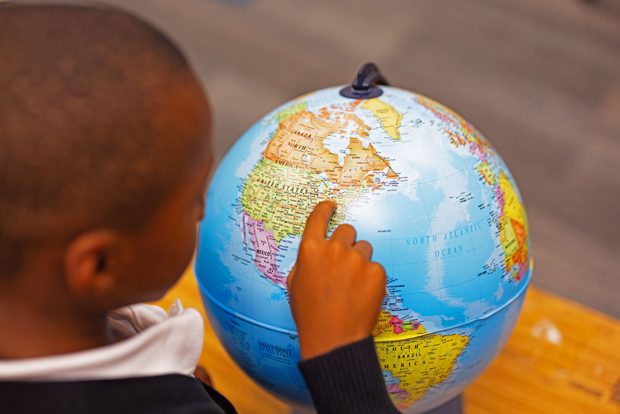 Student with his hand on the globe map