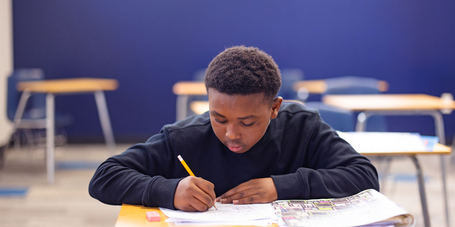 A student in the classroom working on a writing assignment